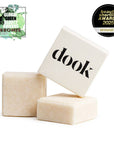 Three soap bars with 'dook' branding on a white background, featuring awards on the left.