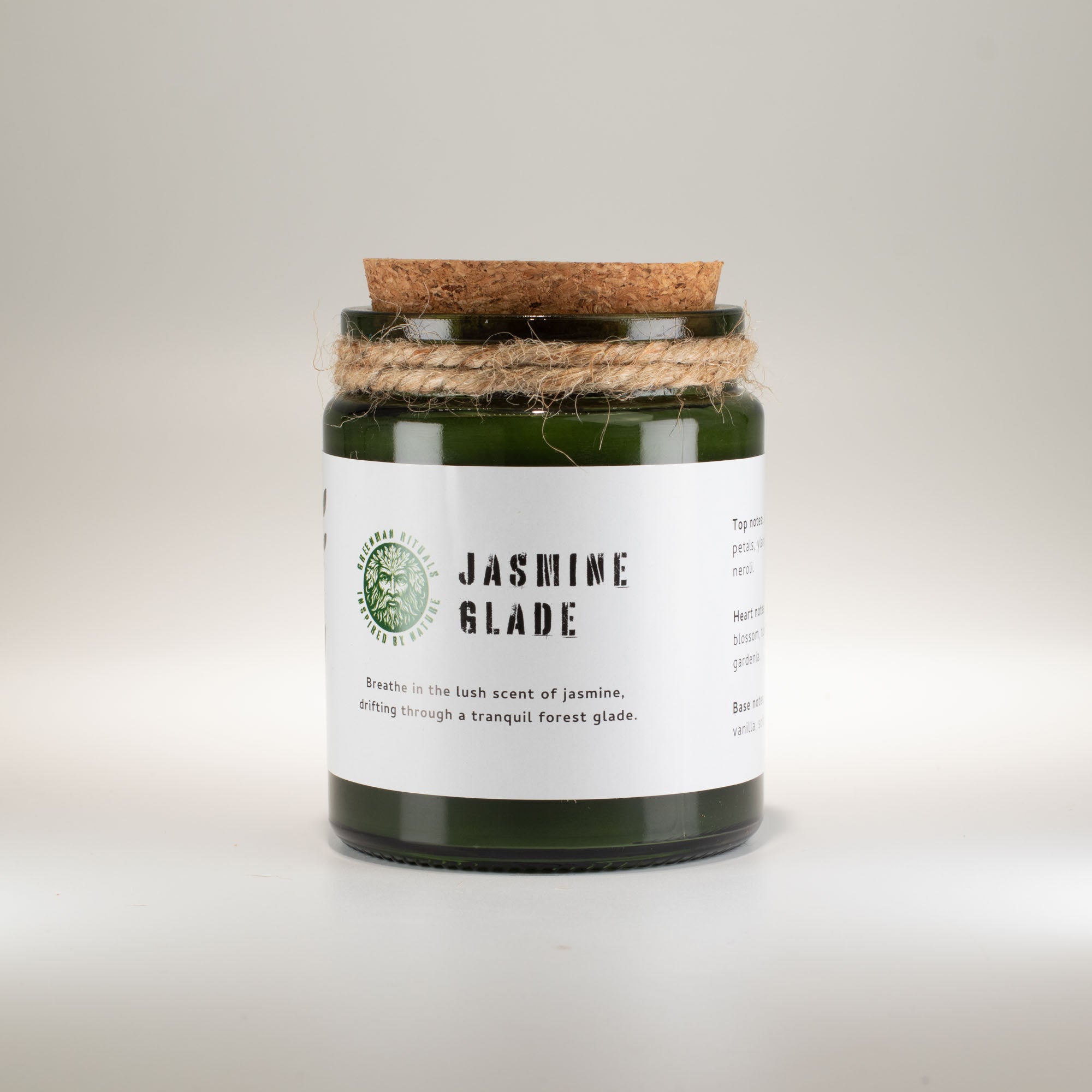 Candle with a label reading 'Jasmine Glade' on a light background