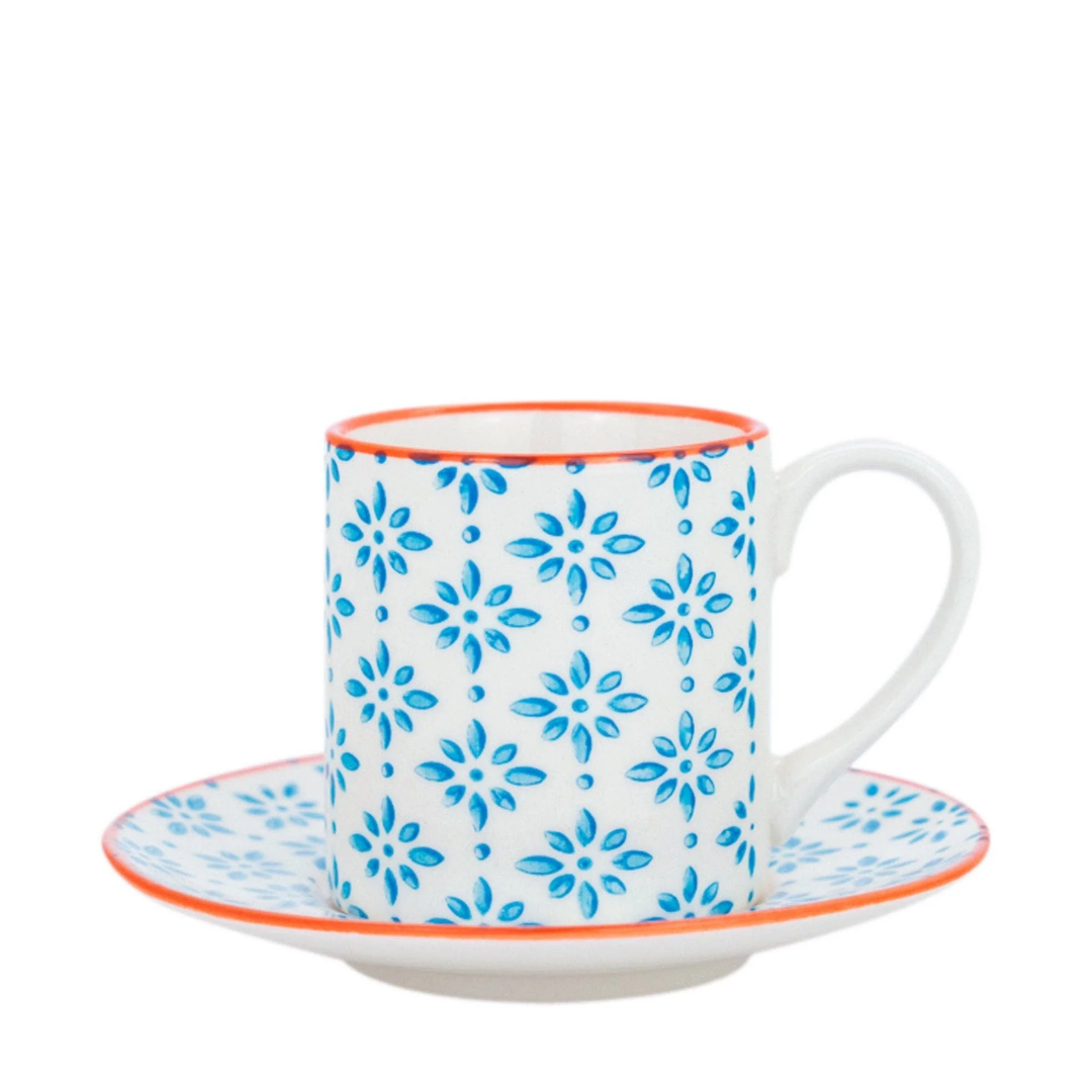 A white ceramic espresso cup and matching saucer set, decorated with a blue floral pattern and accented with a thin orange rim, shown on a plain white background.
