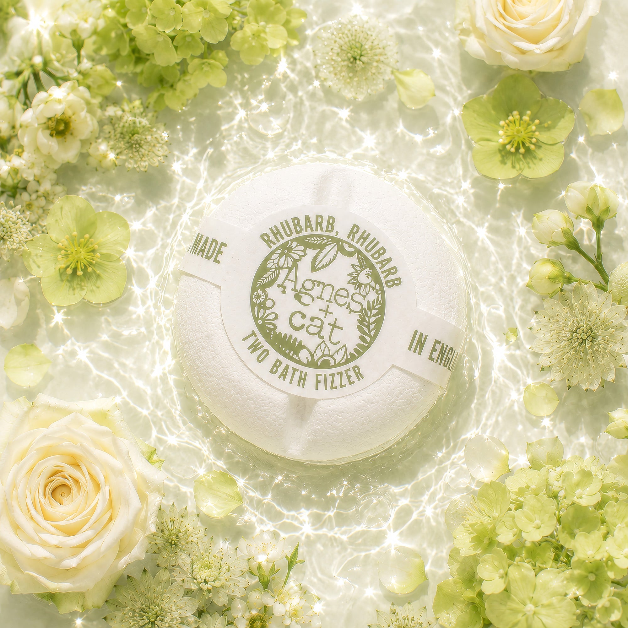 Bath fizzer surrounded by green and white flowers on a light background