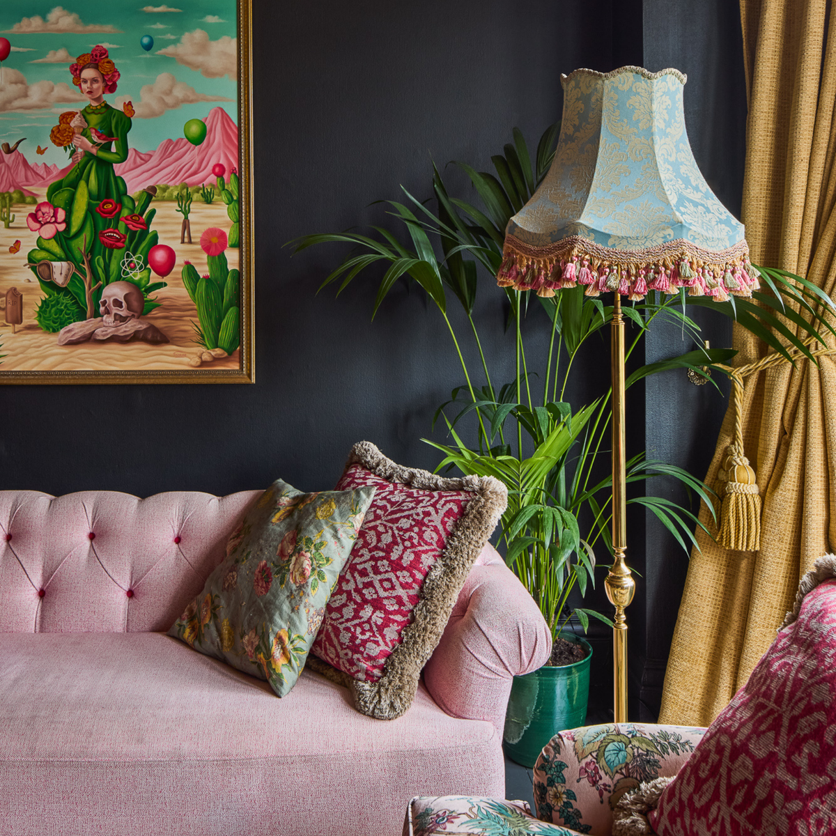 Living room with pink sofa, decorative pillows, and a tall lamp with a patterned shade.