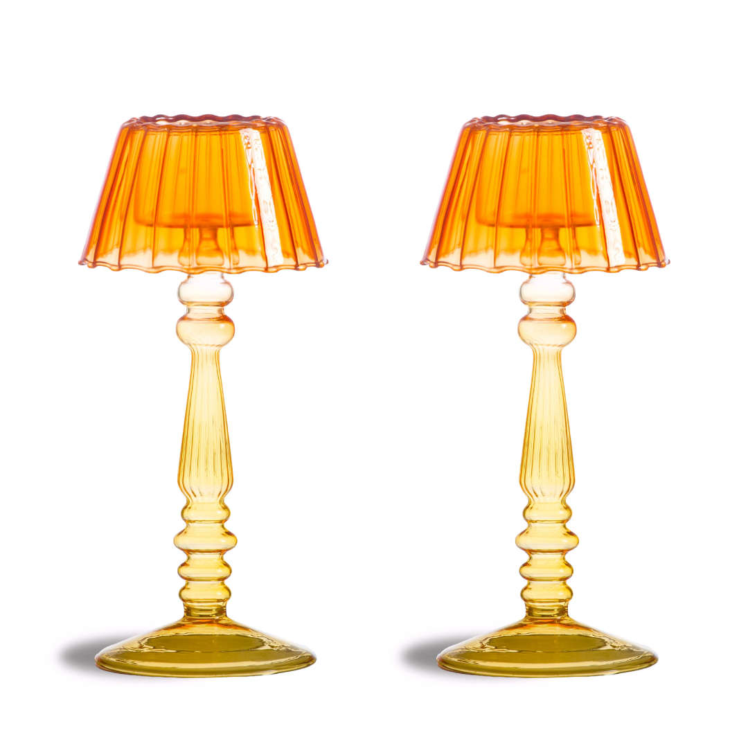 a pair of glass candle holder in orange glass for inside house