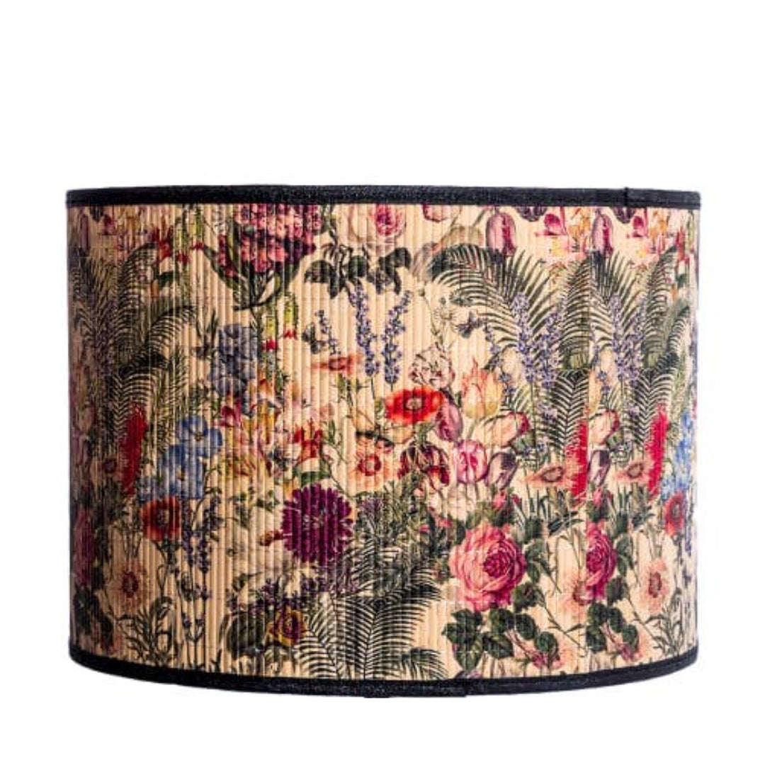 Floral patterned lampshade with a black rim on a white background