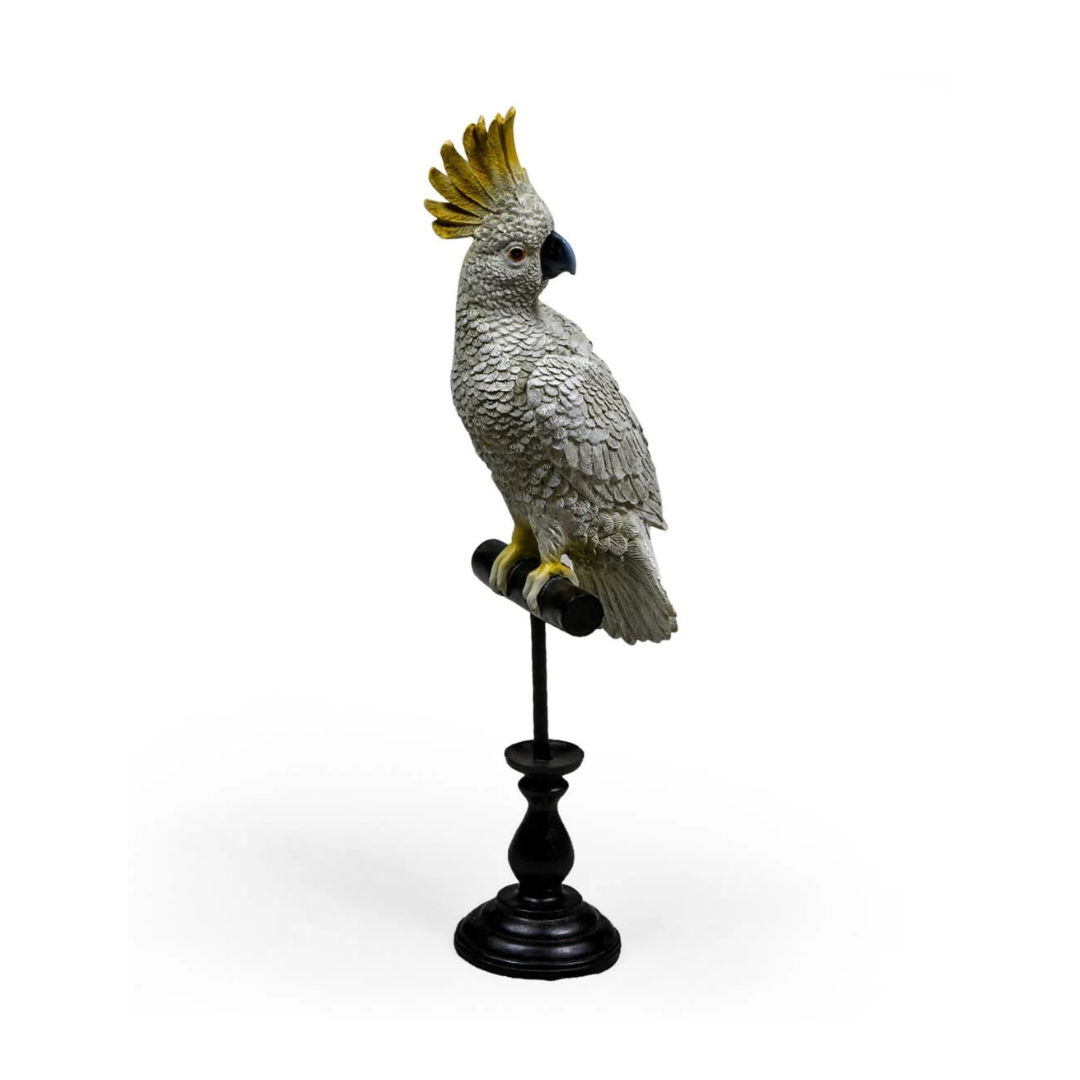 A decorative cockatoo figurine perched on a black stand, shown against a plain white background.