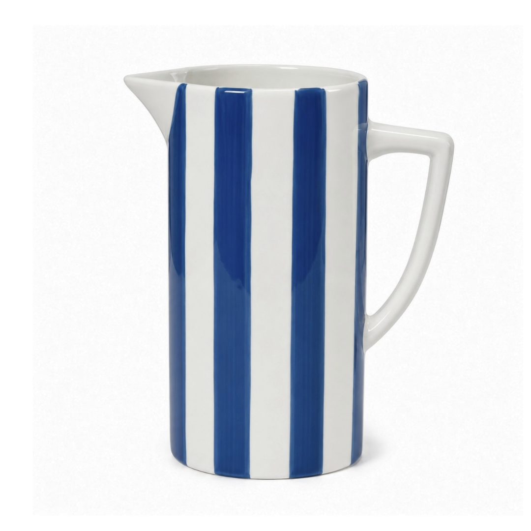 A white ceramic pitcher with bold vertical blue stripes, featuring a curved handle and a small pouring spout, set against a plain white background.