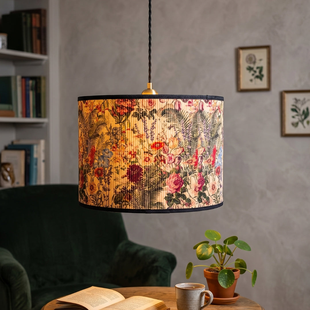 Decorative lamp with floral pattern in a cozy room setting with a book and plant.