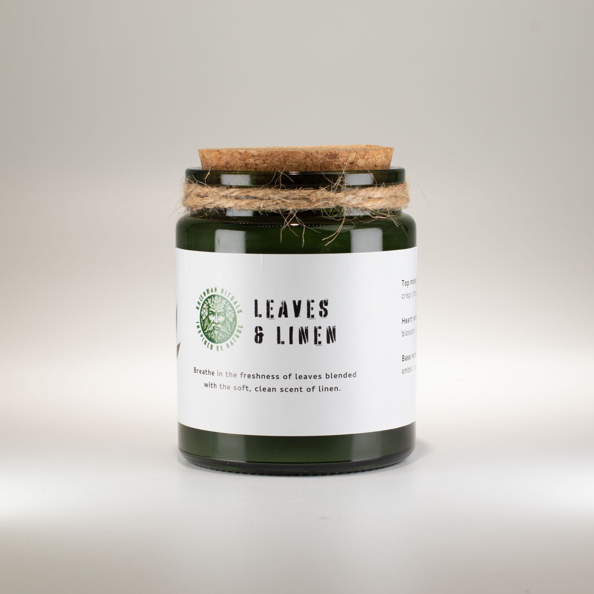 Candle with 'Leaves &amp; Linen' label on a white background