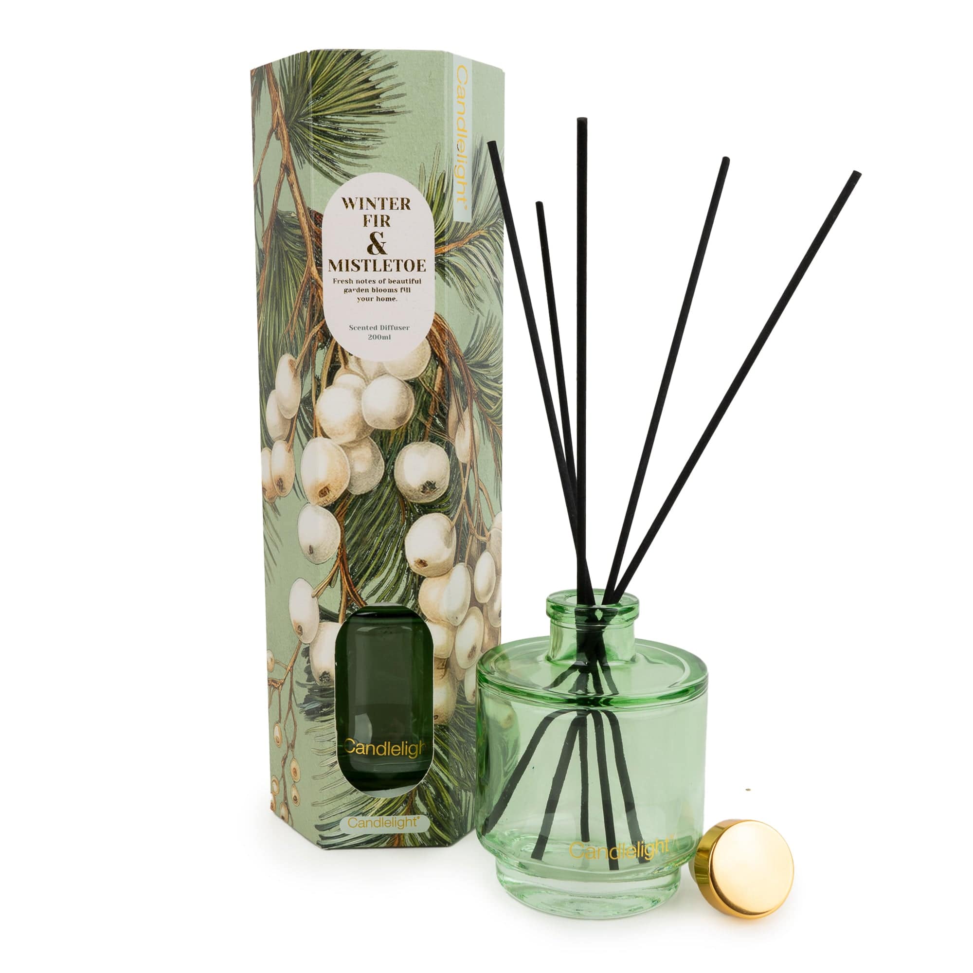 A reed diffuser set with a light green glass bottle, black reeds, a gold cap, and a matching illustrated box featuring mistletoe and pine branches.