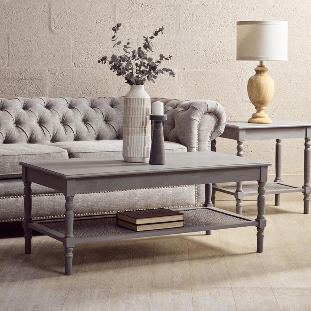 Living room with gray sofa, coffee table, and decorative items.