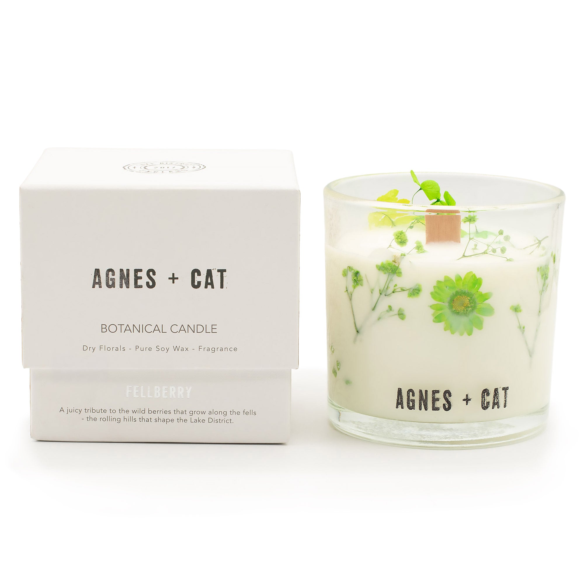 Botanical candle with floral design and matching box labeled 'Agnes + Cat' on a white background