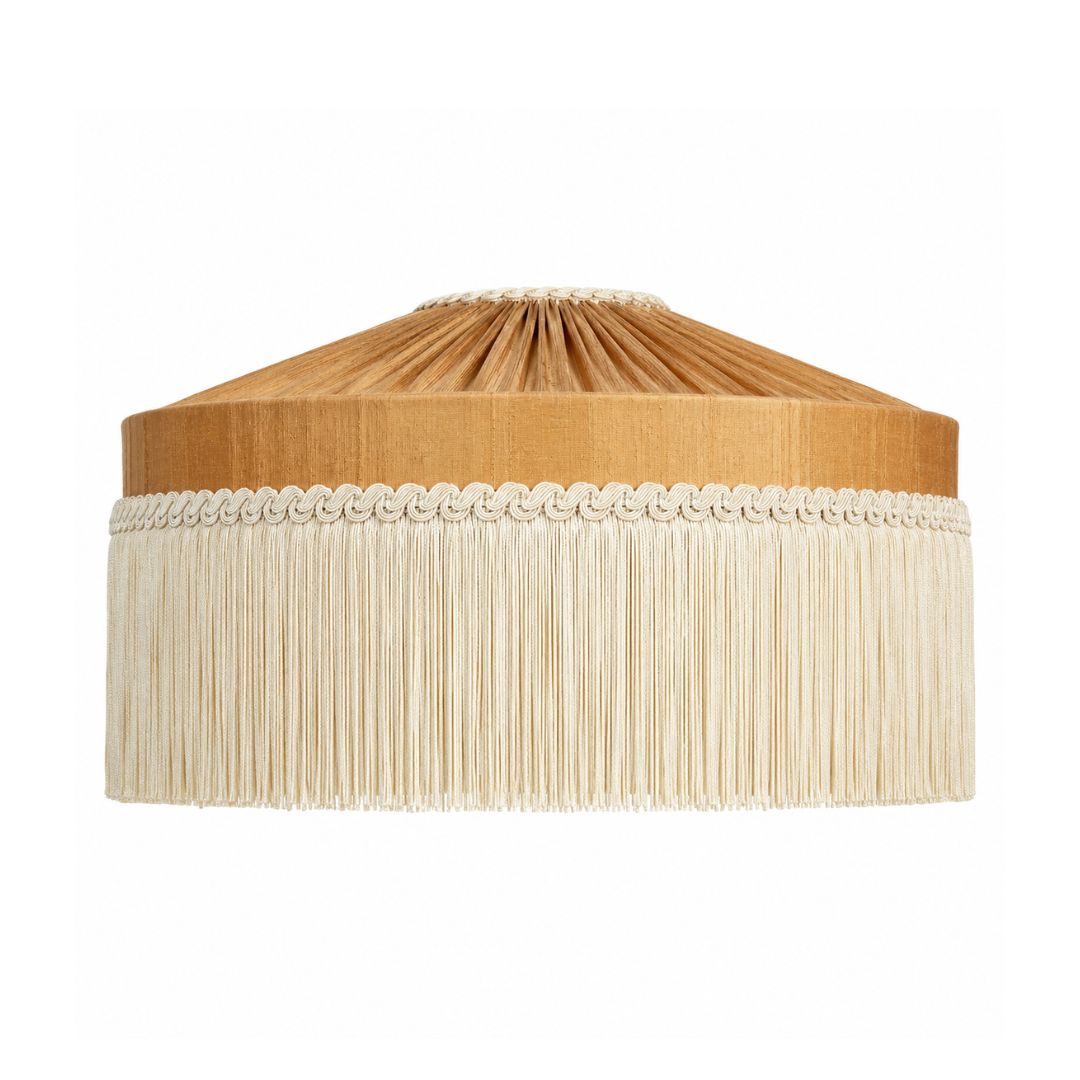 A drum-style pendant light shade with a pleated tan top section, a decorative band of small beads, and a long cream fringe hanging below, shown on a plain white background.