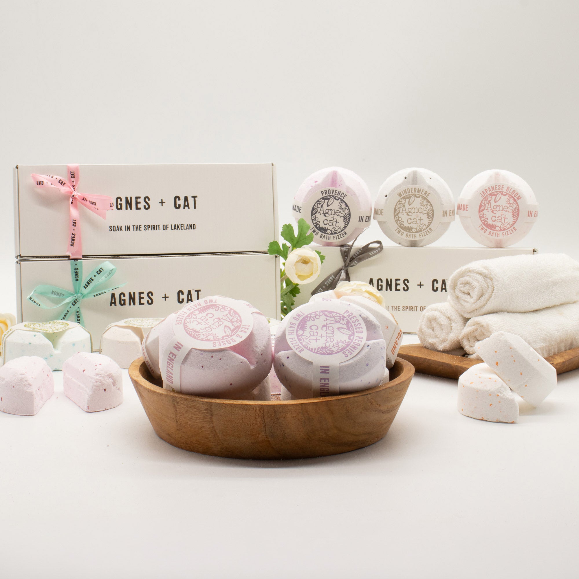 Bath bombs in a wooden bowl with Agnes & Cat packaging in the background