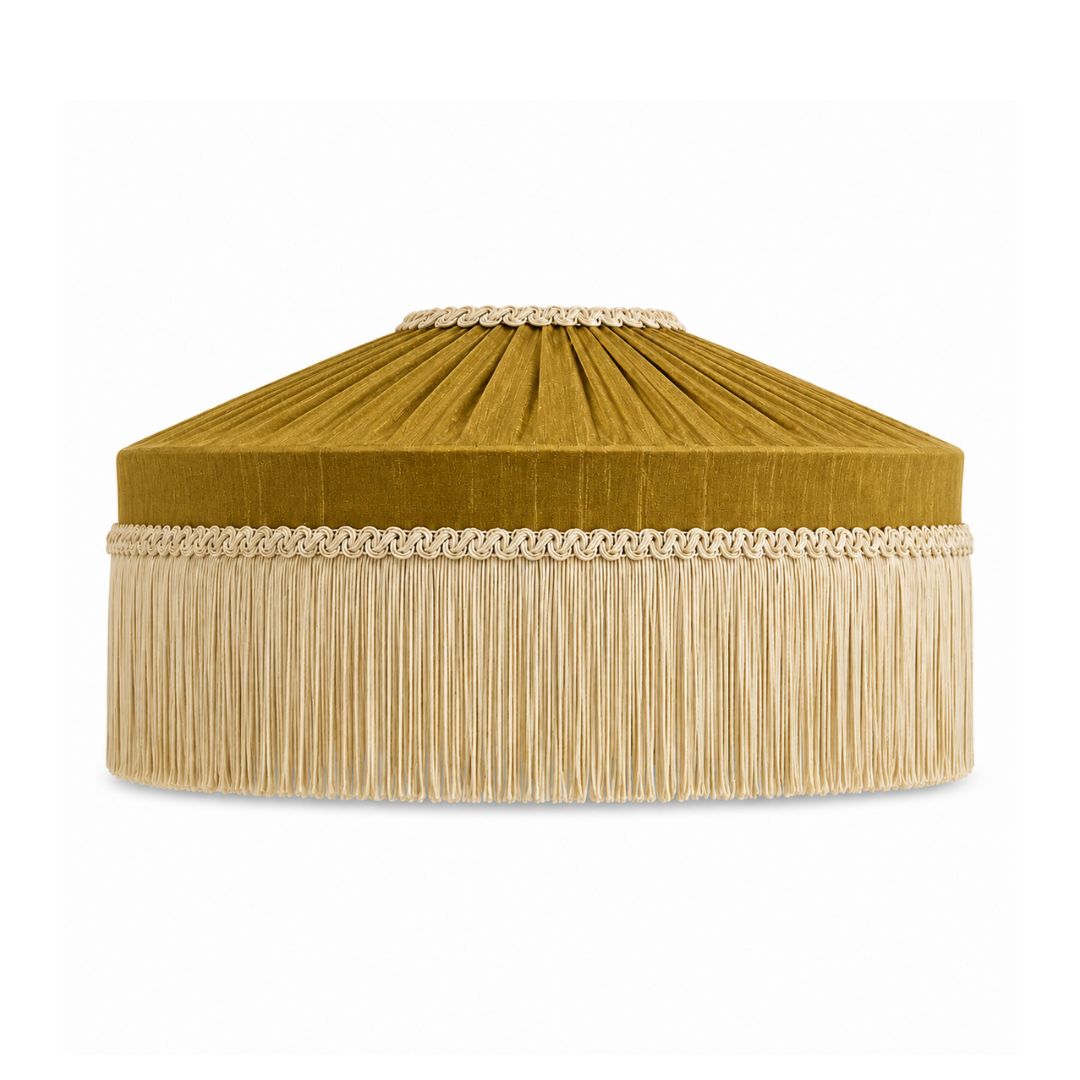 An olive gold velvet dome-shaped cushion cover with a beige fringe trim and decorative braided rope border, shown on a solid white background.