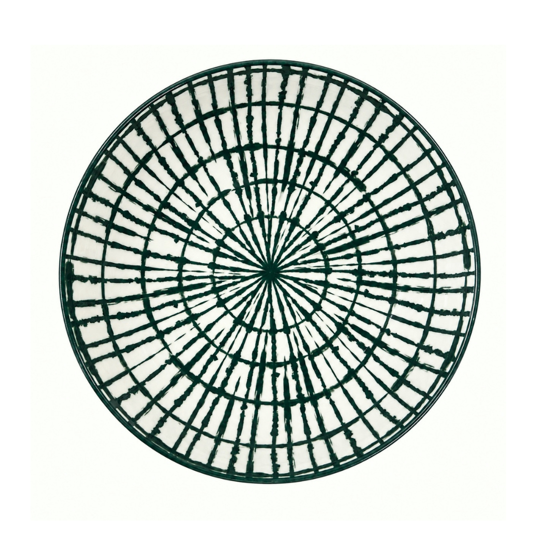 A round white plate with a dark green radial grid pattern, photographed from directly above on a white background.