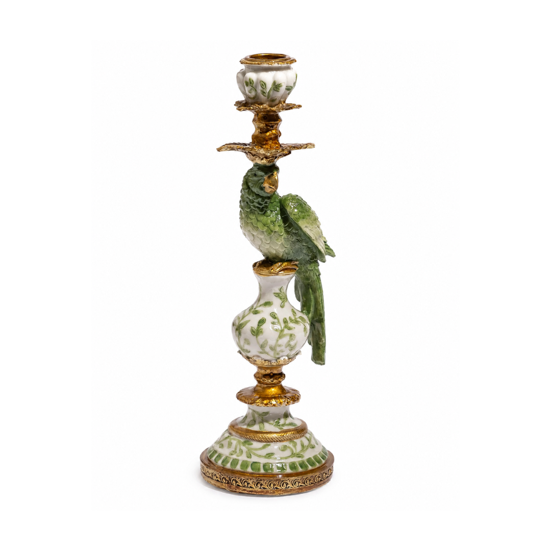 An ornate porcelain candlestick holder featuring a green parrot figurine perched on a white and green patterned vase, with gold accents and a candle holder at the top, set against a plain white background.