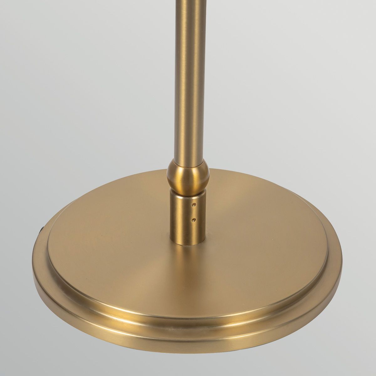 Gold-colored lamp base on a light gray background