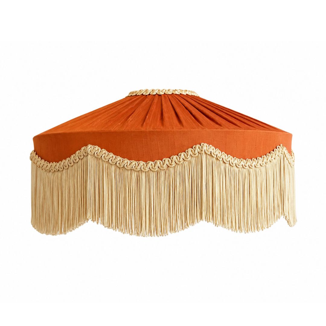 An orange fabric canopy shade with a scalloped fringe trim in a light beige/cream color, featuring a decorative braided rope detail along the top rim.