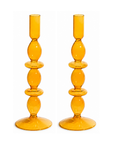 A pair of amber yellow glass candlesticks with a stacked, bulbous design and circular bases, shown on a plain white background.