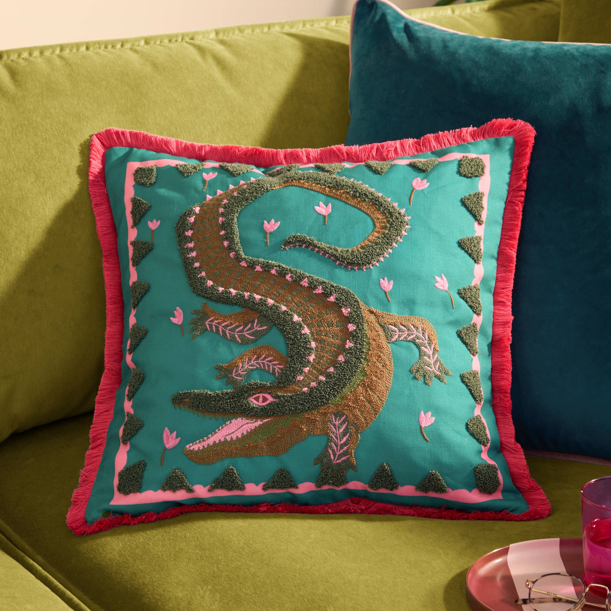 Decorative pillow with crocodile design on a green couch