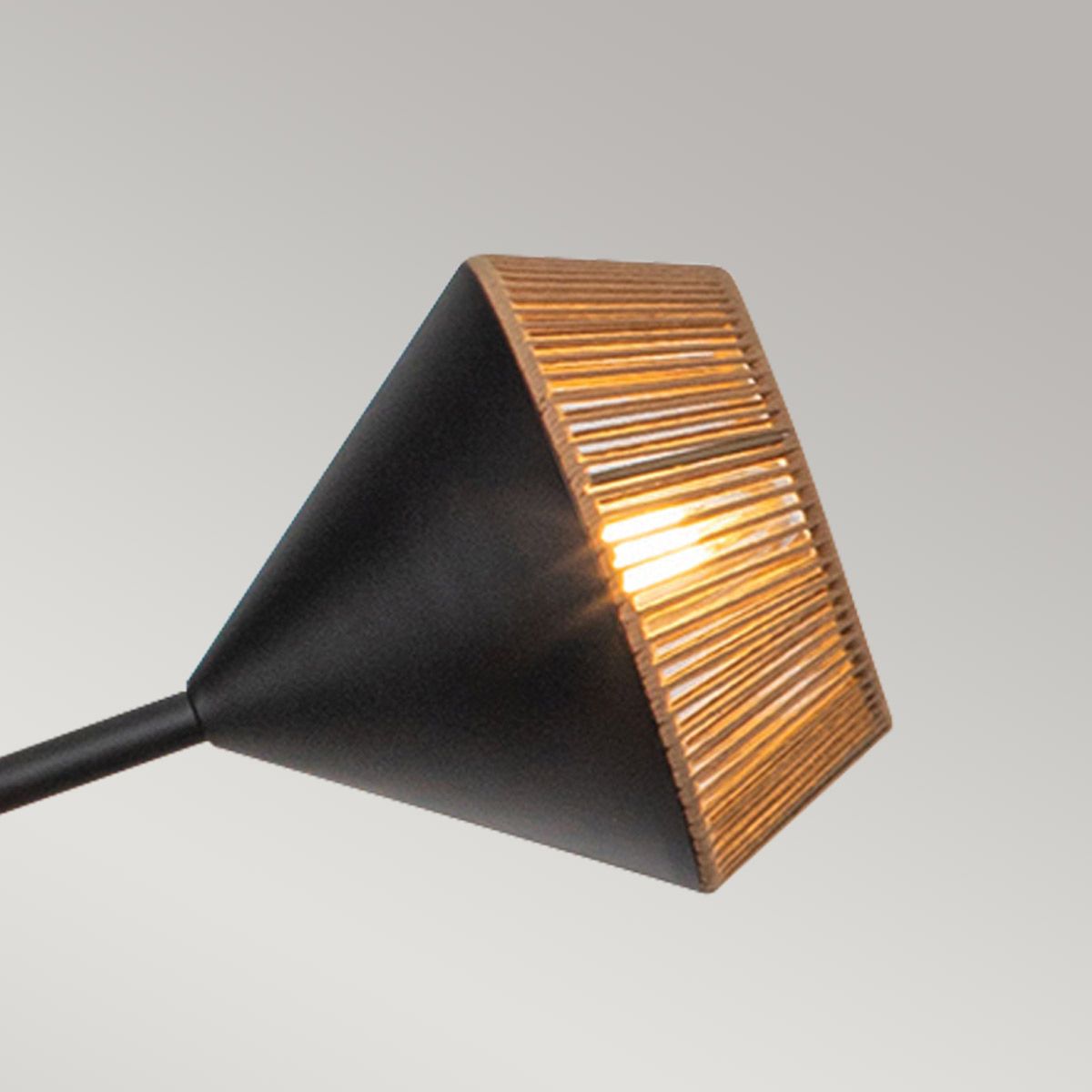 Modern outdoor light fixture with black and copper design on a gray background