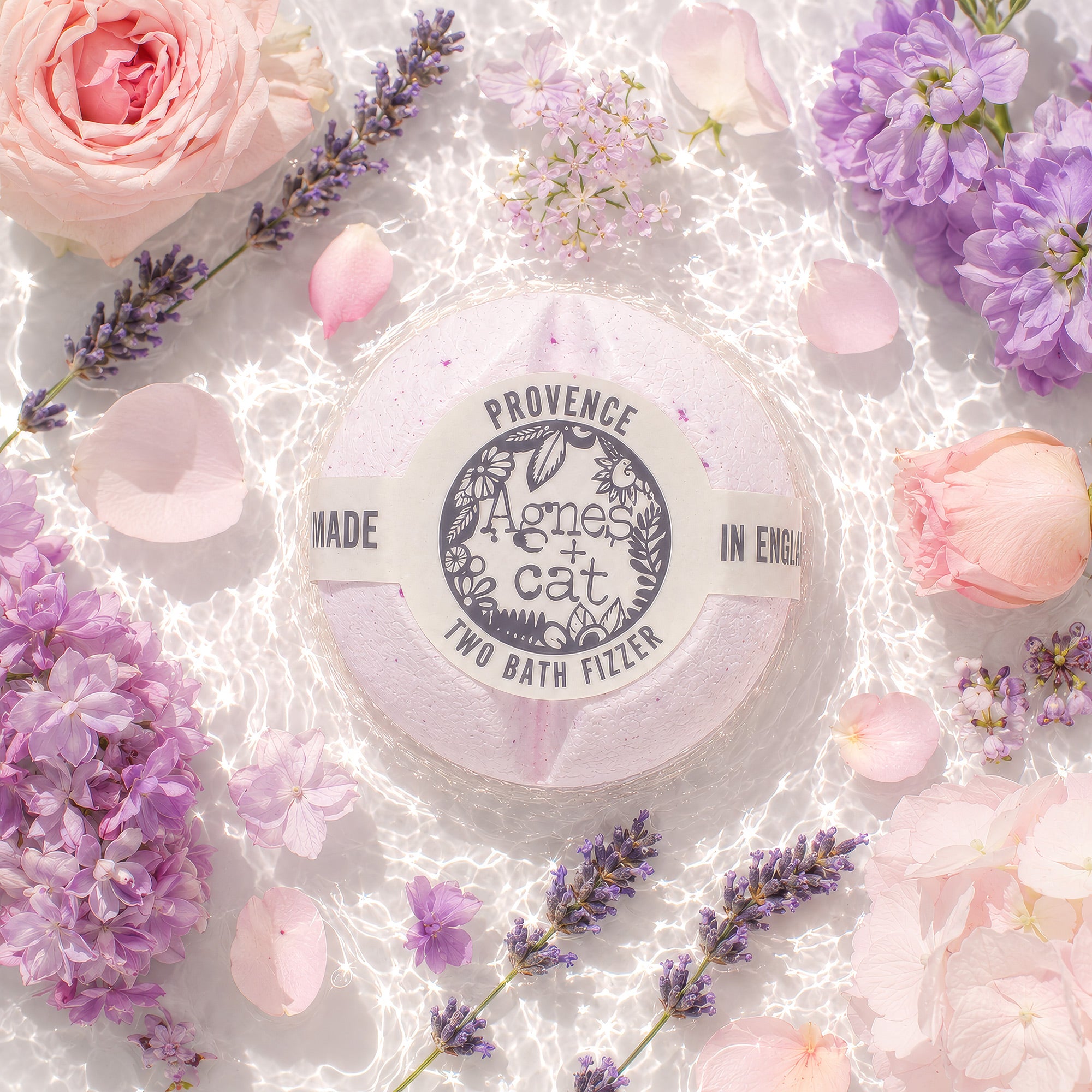 Bath fizzer with 'Agnes & Cat' branding surrounded by flowers on a light background