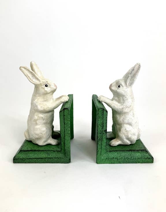 Two rabbit-shaped bookends on green bases against a white background