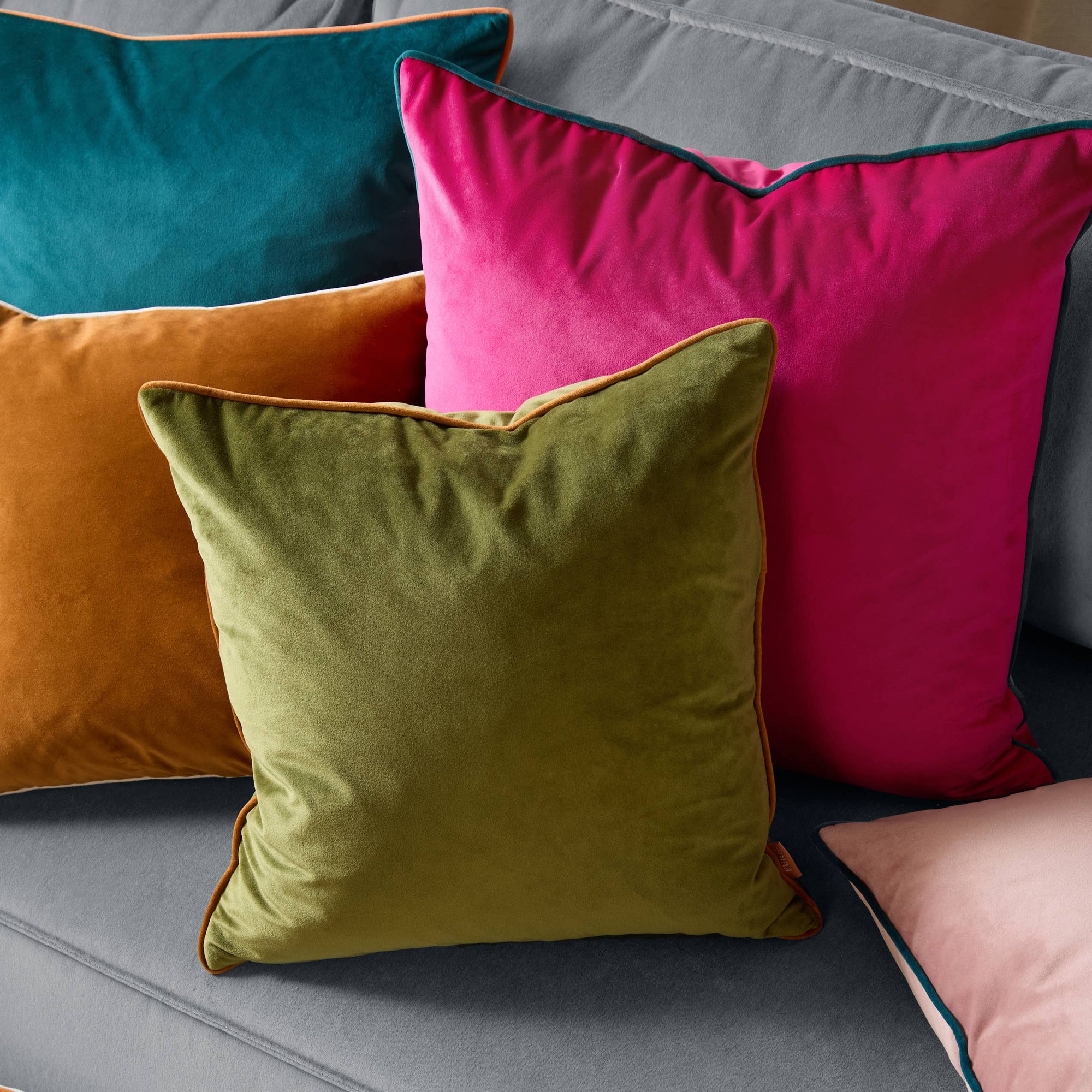 Colorful pillows on a sofa with a focus on a green pillow.