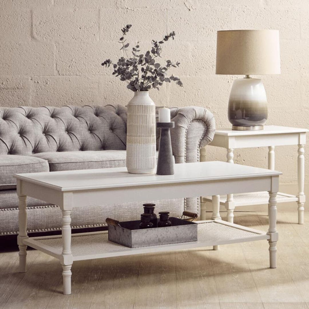 Living room with a white coffee table, gray sofa, and decorative items.